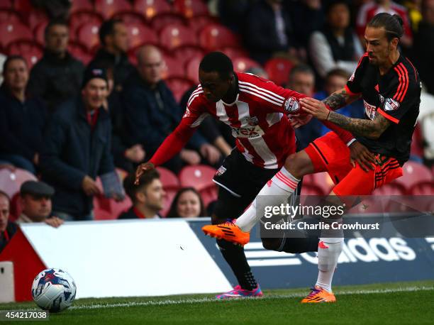 Moses Odubajo of Brentford looks to get past Fulham's Ryan Williams during the Capital One Cup Second Round match between Brentford and Fulham at...