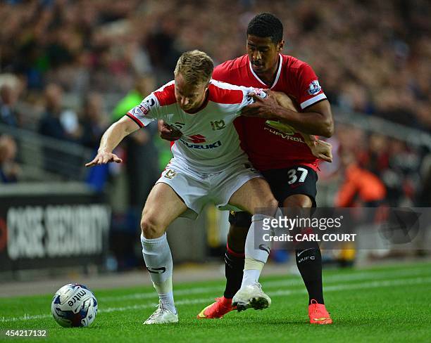 Dons English midfielder Dean Bowditch vies with Manchester United's Swiss defender Saidy Janko during the English League Cup second round football...