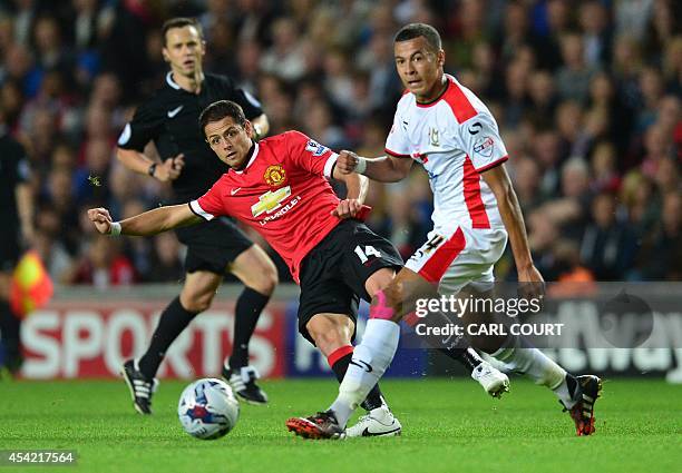 Manchester United's Mexican striker Javier Hernandez passes the ball behind MK Dons English midfielder Dele Alli during the English League Cup second...