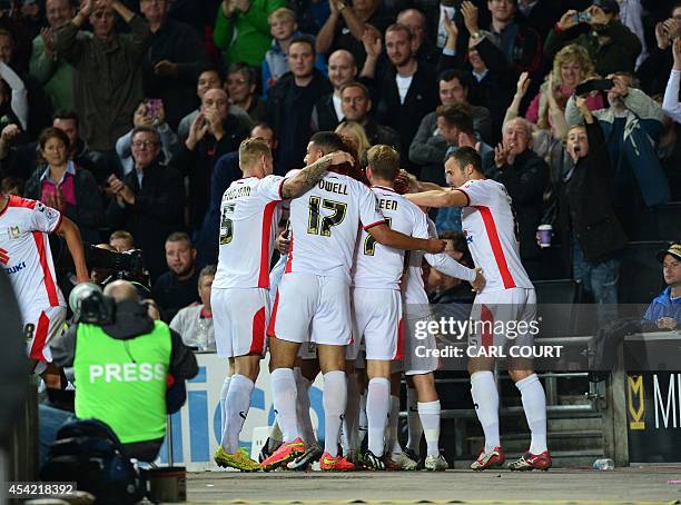 Dons players celebrate their second goal during the English League Cup second round football match between Milton Keynes Dons and Manchester United...