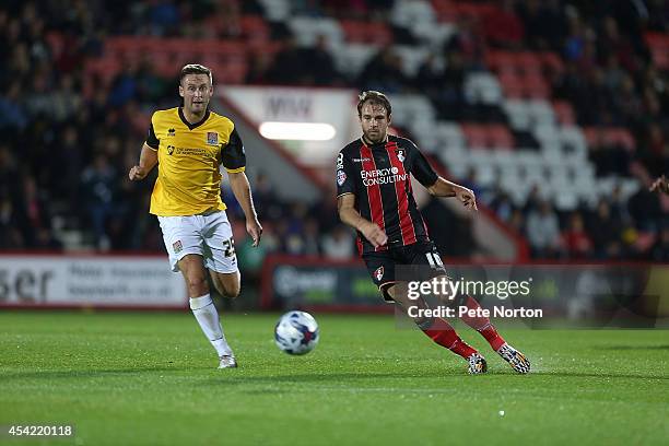 Brett Pitman of AFC Bournemouth plays the ball watched by Joel Byrom of Northampton Town during the Capital One Cup Second Round match between AFC...