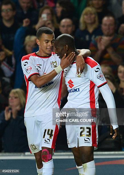 Dons English midfielder Dele Alli congratulates MK Dons English striker Benik Afobe on scoring their fourth goal during the English League Cup second...