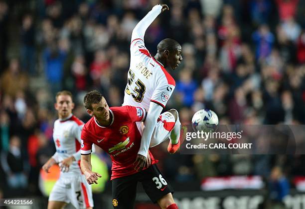 Manchester United's Belgian defender Marnick Vermijl vies with MK Dons English striker Benik Afobe during the English League Cup second round...