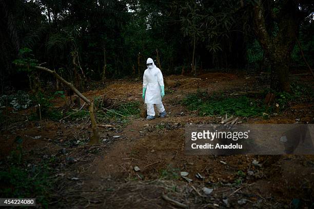 Member of a volunteer medical team wears special uniform for the burial of 7 people, sterilized after dying due to the Ebola virus, in Kptema...