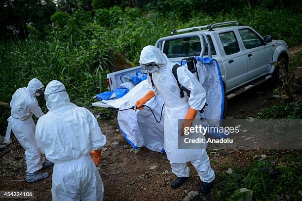 Members of a volunteer medical team wear special uniforms for the burial of 7 people, sterilized after dying due to the Ebola virus, in Kptema...