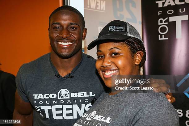 Detroit Lions running back Reggie Bush and $10,000 scholarship winner Bria Gregory pose at the Touchdown For Teens Campaign at Taco Bell on August...