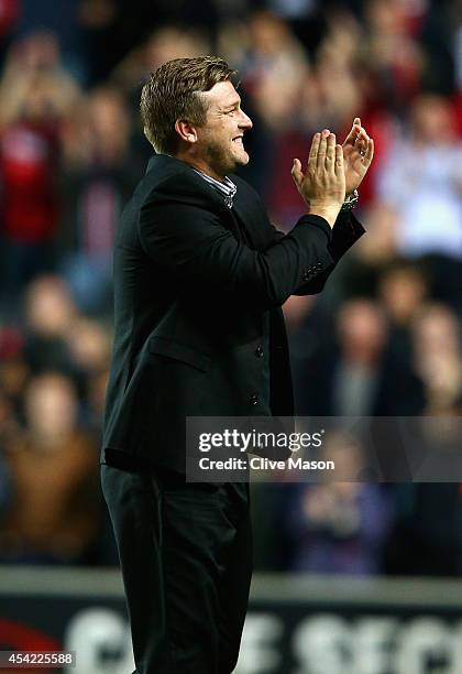 Karl Robinson of MK Dons applauds the crowd after the Capital One Cup second round match between MK Dons and Manchester United at Stadium mk on...