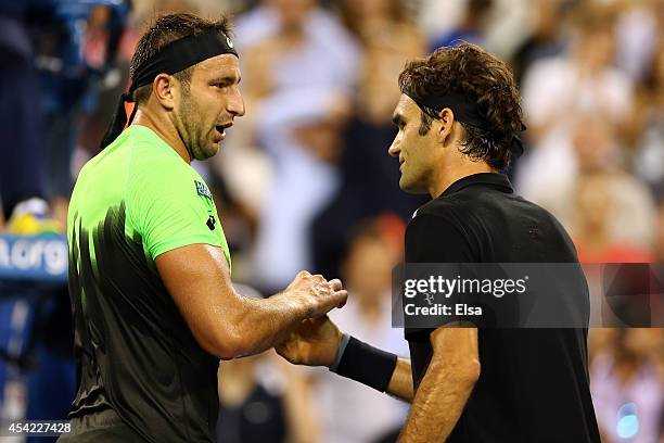 Roger Federer of Switzerland meets Marinko Matosevic of Australia during after defeating him in their men's singles first round match on Day Two of...