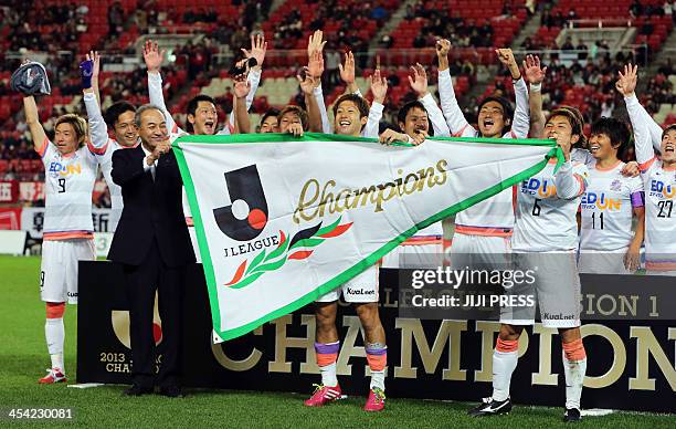 This picture taken on December 7, 2013 shows Sanfrecce Hiroshima team members celebrating their victory of J-League's top division as they defeated...