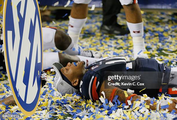 Quarterback Nick Marshall of the Auburn Tigers celebrates in confetti after defeating the Missouri Tigers 59-42 to win the SEC Championship Game at...