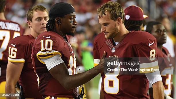 Washington Redskins quarterback Robert Griffin III consoles Washington Redskins quarterback Kirk Cousins after Cousins' offense was forced to attempt...