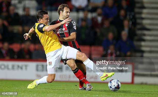 Gregor Robertson of Northampton Town contests the ball with Brett Pitman of AFC Bournemouth during the Capital One Cup Second Round match between AFC...