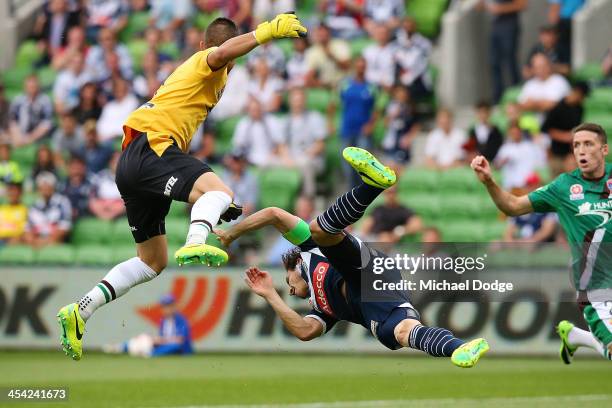 Mark Milligan of the Victory and Jets keeper Mark Birighitti collide after contesting for the ball during the round nine A-League match between the...