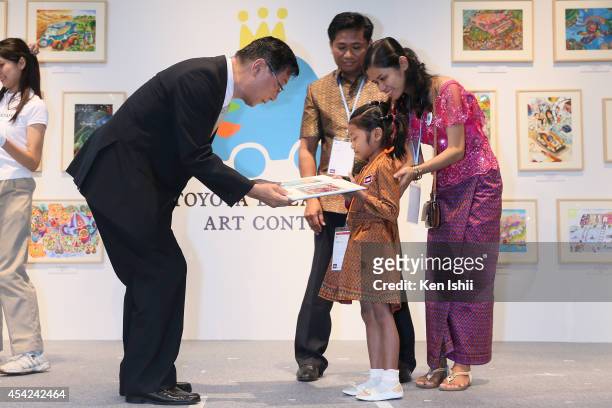 Mealaksey Pha of Cambodia , winner of President Akio Toyoda award, accepts her award from Yasumori Ihara, Senior Vice President of Toyota Motor...