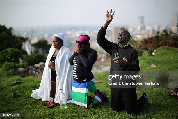 People worship on a hill overlooking Johannesburg as they remember and mourn Nelson Mandela. South Africans are observing a national day of prayer in...