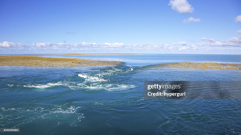 Blue water background with reef on low tide.