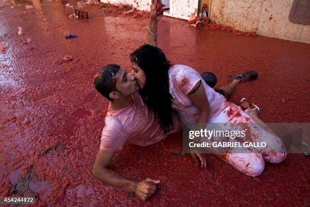 Couple kisses during the annual "tomatina" festivities in the village of Bunol, near Valencia on August 27, 2014. Some 22,000 revellers hurled 130...