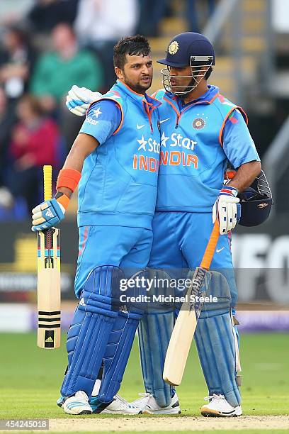 Suresh Raina of India is congratulated by capatin MS Dhoni after reaching his century during the second Royal London One-Day Series match between...