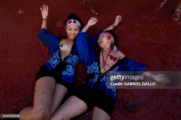 Tourists lie in pulp during the annual "tomatina" festivities in the village of Bunol, near Valencia on August 27, 2014. Some 22,000 revelers hurled...