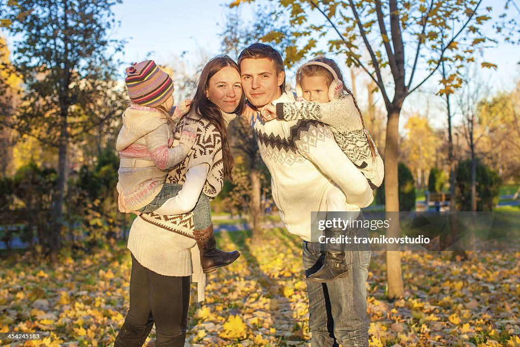 Family of four having fun in autumn park