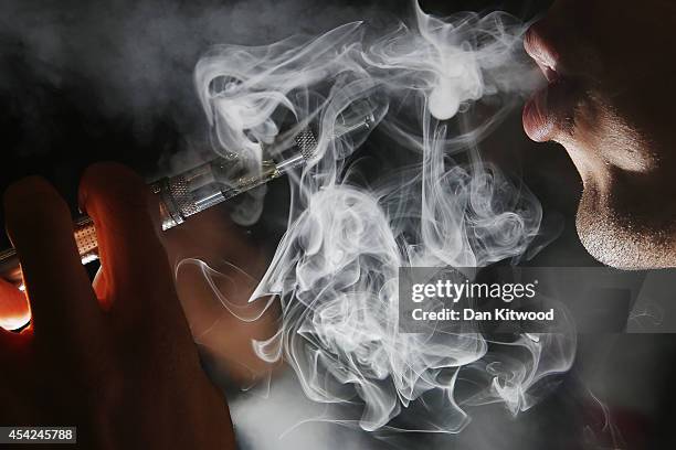 In this photo illustration, a man smokes an E-Cigarette at the V-Revolution E-Cigarette shop in Covent Garden on August 27, 2014 in London, England....