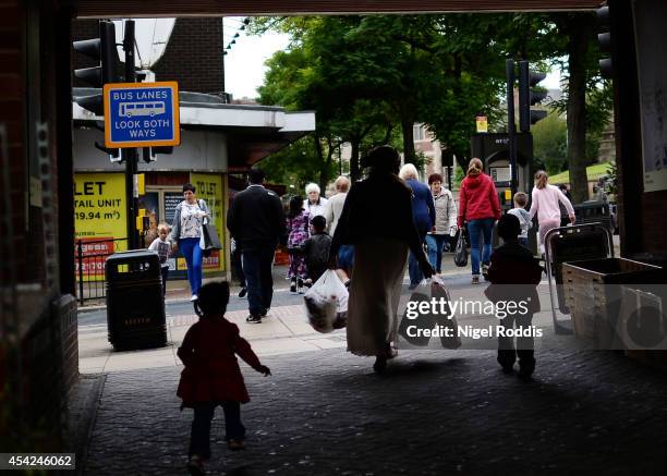 Shoppers walk through the streets of Rotherham, South Yorkshire August 27, 2014 in Rotherham, England. A report released yesterday claims at least...