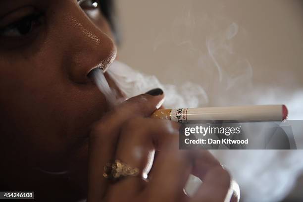 In this photo illustration, a woman smokes an E-Cigarette at the V-Revolution E-Cigarette shop in Covent Garden on August 27, 2014 in London,...