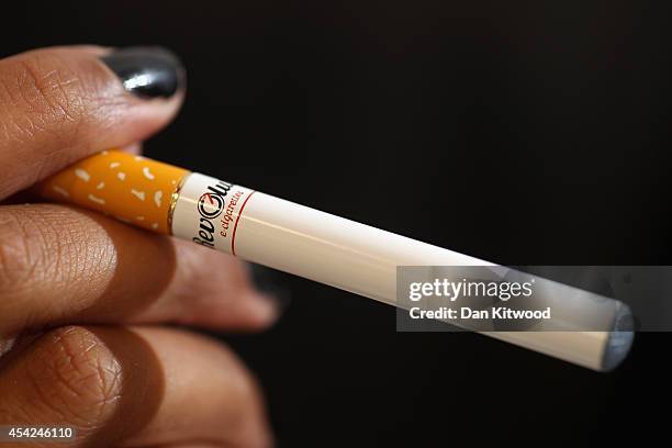 In this photo illustration, a woman smokes an E-Cigarette at the V-Revolution E-Cigarette shop in Covent Garden on August 27, 2014 in London,...