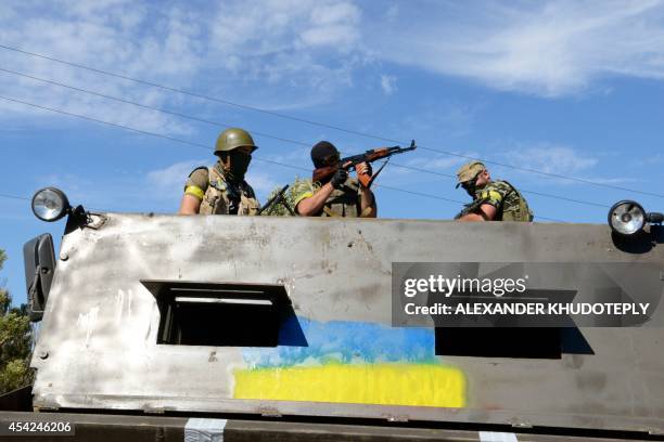 Members of Ukrainian volunteer battalion Dnipro stand in a truck covered in steel plates near the small southern Ukrainian city of Novoazovsk,...