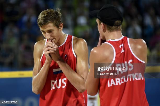 Oleg Stoyanovskiy and Artem Larzutkin of Russia compete with Jose Gregorio Gomez and Rolando Hernandez of Venezuela in the Men's Beach Volleyball...