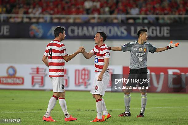 Tomi Juric and Mark Bridge of Western Sydney Wanderers celebrates winning a penalty while Zeng Cheng of Guangzhou Evergrande reacts during the Asian...