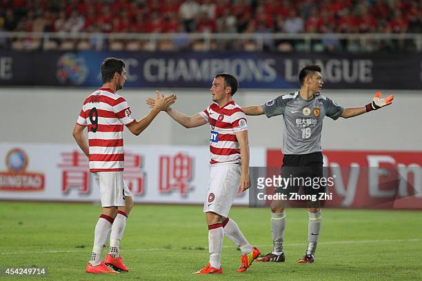 Tomi Juric and Mark Bridge of Western Sydney Wanderers celebrates winning a penalty while Zeng Cheng of Guangzhou Evergrande reacts during the Asian...