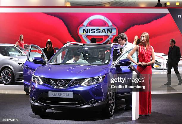 Visitors inspect a Nissan Qashqai automobile, manufactured by Nissan Motor Co., at the Moscow International Auto Salon in Moscow, Russia, on...
