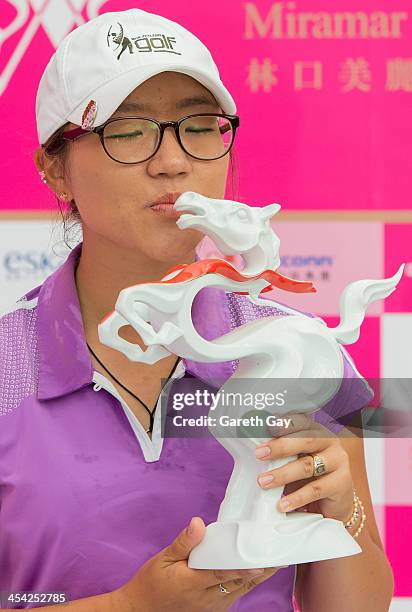 Lydia Ko of New Zealand, with the winning score of Eleven under par, kisses her trophy, during the last day of the Swinging Skirts 2013 World Ladies...