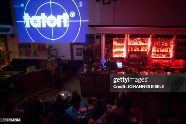 People watch the screening of German TV series 'Tatort" at the "Volksbar" in Berlin on November 24, 2013. More than 10 million Germans regularly tune...