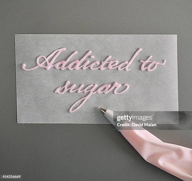 "addicted to sugar" written in icing sugar. - icing bag stock pictures, royalty-free photos & images