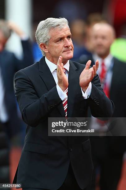 Stoke City manager Mark Hughes applauds the crowd as he walks out for the Capital One Cup Second Round match between Stoke City and Portsmouth at...