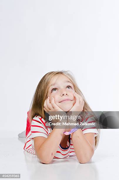 daydreaming little girl - leaning on elbows stock pictures, royalty-free photos & images
