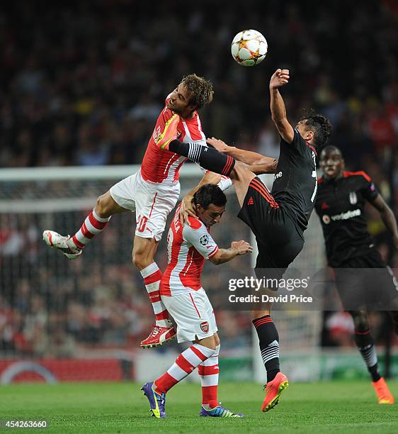 Mathieu Flamini and Santi Cazorla of Arsenal challenge Mustafa Pektemek of Besiktas during the UEFA Champions League Qualifing match between Arsenal...