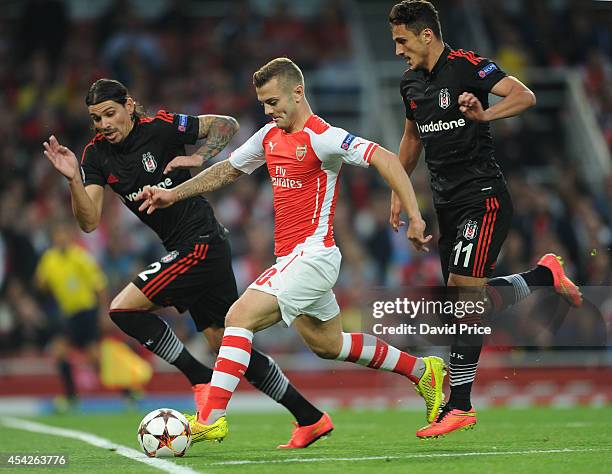 Jack Wilshere of Arsenal takes on Ersan Gulum and Mustafa Pektemek of Besiktas during the UEFA Champions League Qualifing match between Arsenal and...