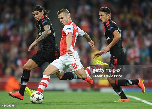 Jack Wilshere of Arsenal takes on Ersan Gulum and Mustafa Pektemek of Besiktas during the UEFA Champions League Qualifing match between Arsenal and...