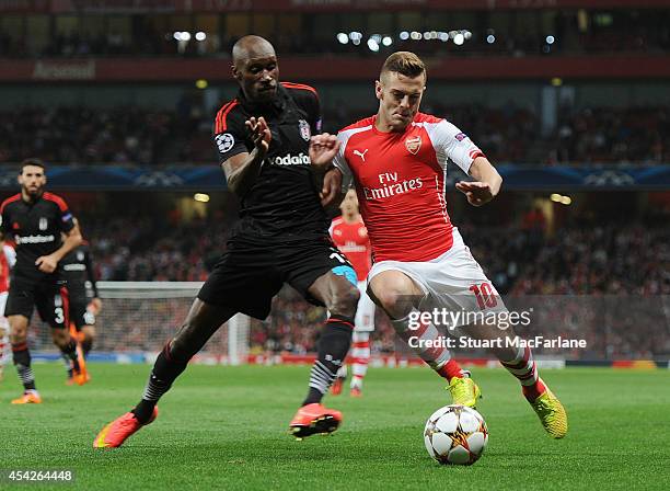 Jack Wilshere of Arsenal challenged by Atiba Hutchinson of Besiktas during the UEFA Play Off match between Arsenal and Besiktas at Emirates Stadium...