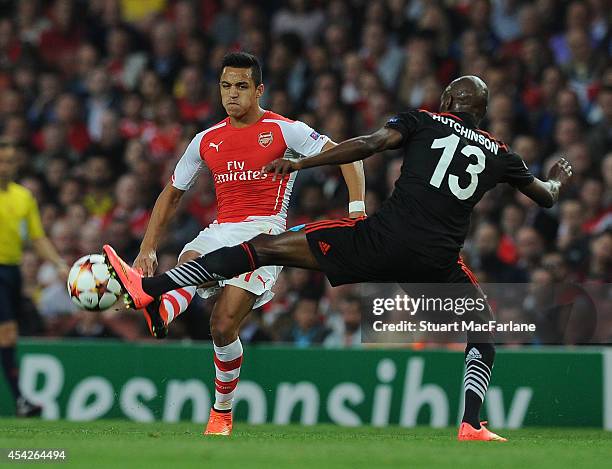 Alexis Sanchez of Arsenal challenged by Atiba Hutchinson of Besiktas during the UEFA Play Off match between Arsenal and Besiktas at Emirates Stadium...