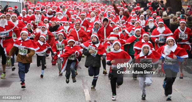 Participants leave the starting line in the 5th annual Michendorf Santa Run on December 8, 2013 in Michendorf, Germany. Over 900 people took part in...
