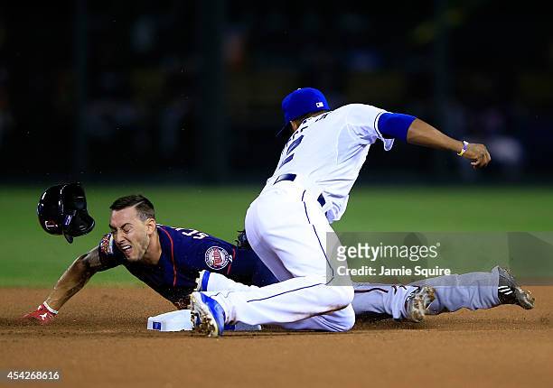 The helmet of Jordan Schafer of the Minnesota Twins pops off as he slides safely into second base for a steal as Alcides Escobar of the Kansas City...