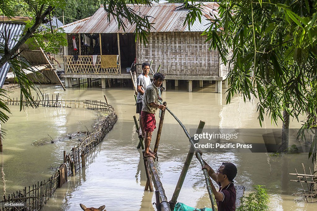 A flood affected family making a makeshift bamboo bridge...