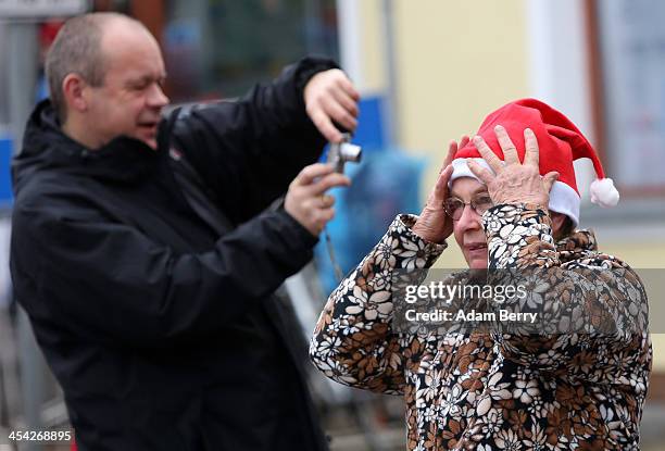 Resident adjusts her Santa Claus hat as she watches the 5th annual Michendorf Santa Run on December 8, 2013 in Michendorf, Germany. Over 900 people...