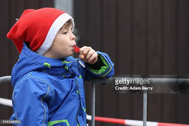 Child blows a whistle as he watches the 5th annual Michendorf Santa Run on December 8, 2013 in Michendorf, Germany. Over 900 people took part in this...