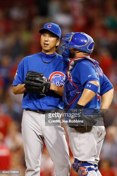Kyuji Fujikawa and Welington Castillo of the Chicago Cubs talk prior to the seventh inning of the game against the Cincinnati Reds at Great American...
