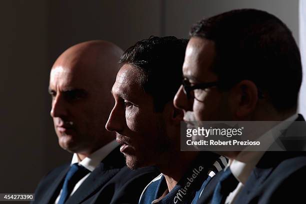 Captain Mark Milligan speaks to the media as coach Kevin Muscat and chairman Anthony Di Pietro look on during a Melbourne Victory A-League media...